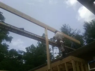 Carpenter setting a ridge beam over a new addition frame — Ice Dam Removal by Roofing Brothers in West Decatur