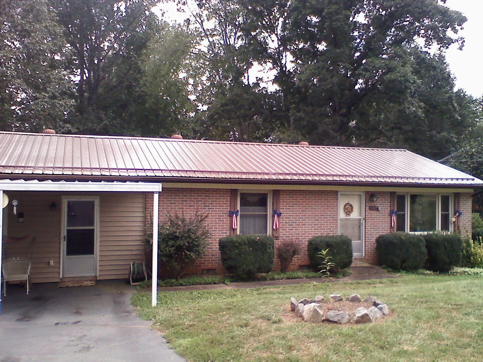Bronze metal roof and carport on a brick ranch home — Roof Repair work by our crew in West Decatur